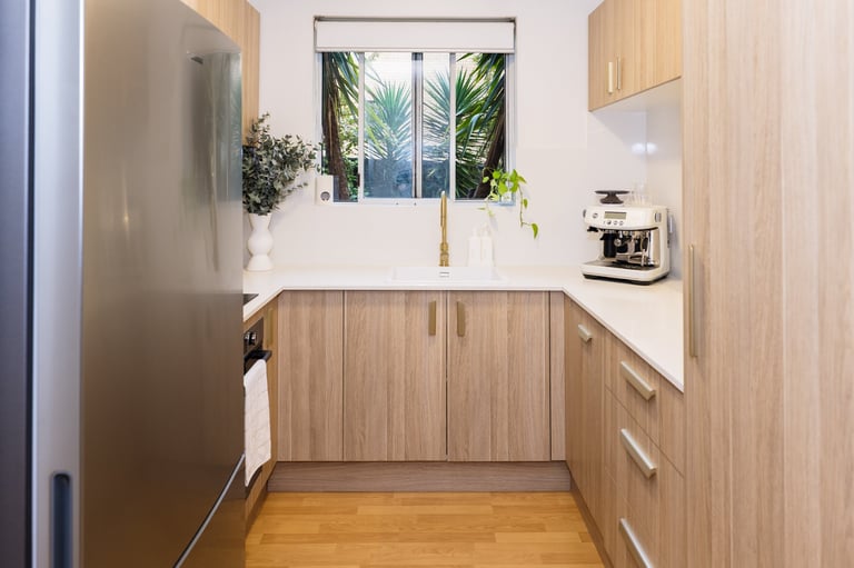 Modern kitchen in Caringbah apartment renovation by ACG Built Sutherland Shire — light wood cabinetry and stainless steel appliances