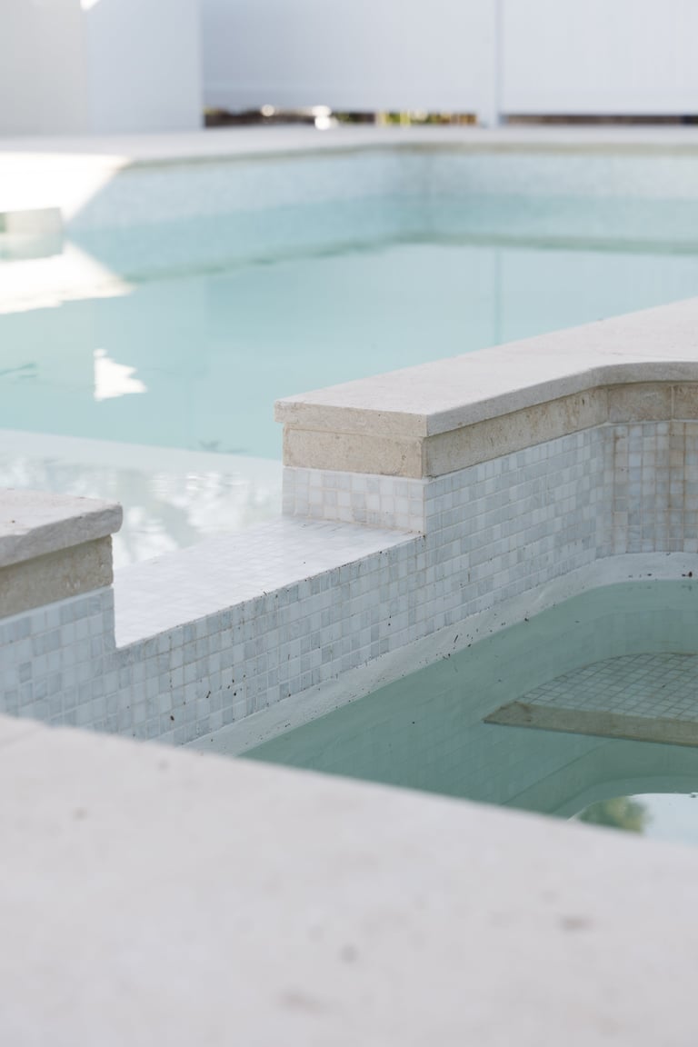 Modern spa or hot spring facility with multiple turquoise thermal pools separated by stone and tile walls